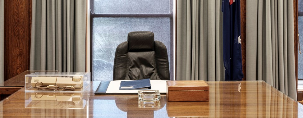Former prime minister Bob Hawke's desk, complete with blue binder, ash tray, wooden box and old phone. Australian flag in the background. Former prime minister Bob Hawke's desk, complete with blue binder, ash tray, wooden box and old phone. Australian flag in the background.