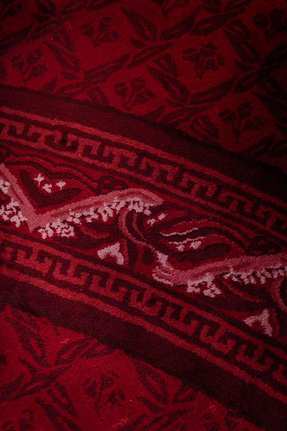 A close up of red carpet with an ornate pattern. A close up of red carpet with an ornate pattern.